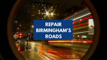 A blurred picture of an open road through a city centre. Text with a blue underlay reads, Repair Birmingham's Roads.